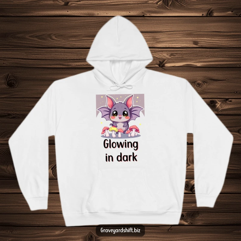 Funny bat juggling hoodie, wide eyes, glowing mushrooms in the dark, perfect for cozy and magical wear.